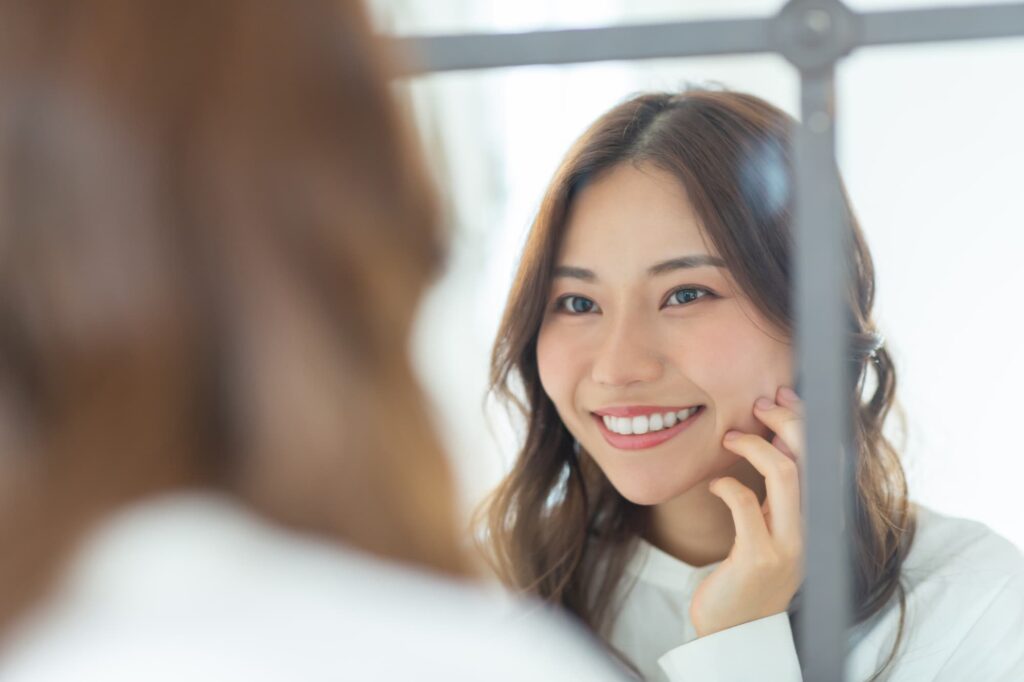 白くなった歯を鏡で確認して嬉しそうな女性