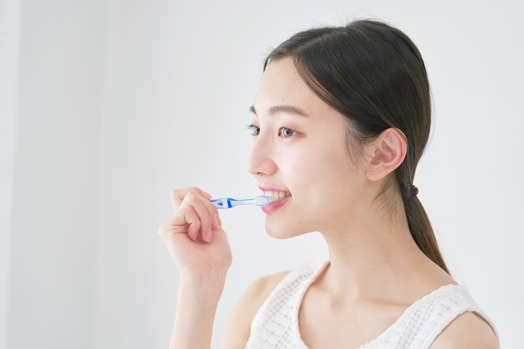 前歯の裏が虫歯になるのを予防するために丁寧に歯磨きする女性